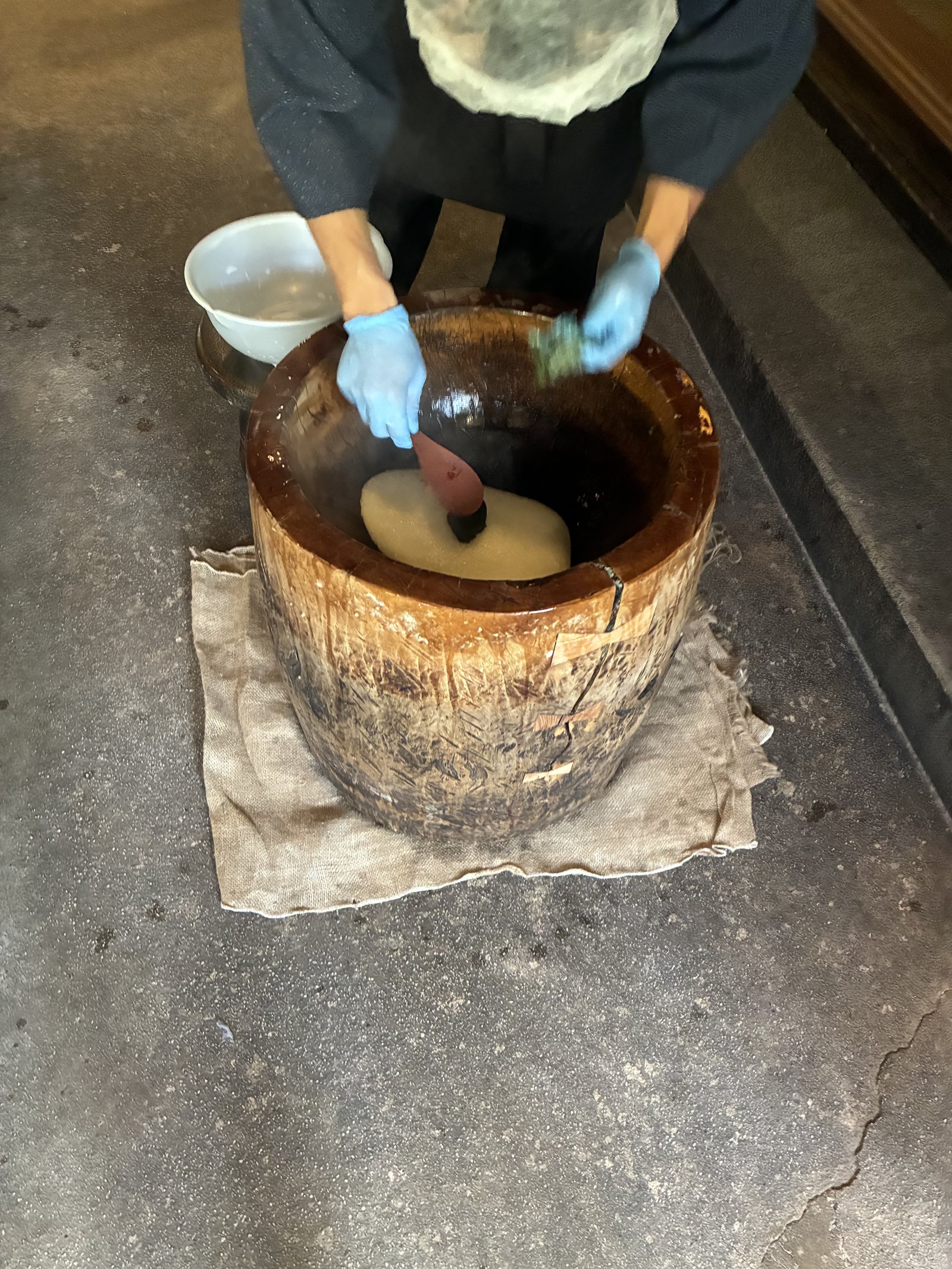 Morning mochi-pounding ritual at the Yarimikan lobby with a wooden mortar and pestle