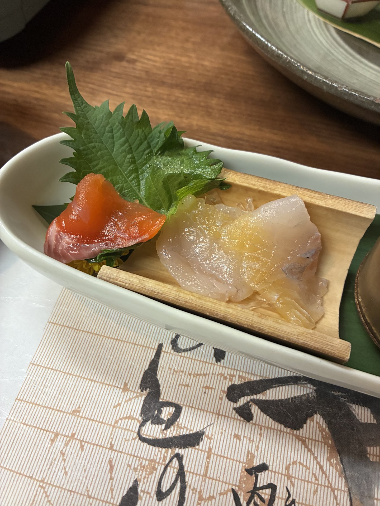 Hida catfish (namazu) sashimi at Yarimikan served on a wooden boat with shiso leaf