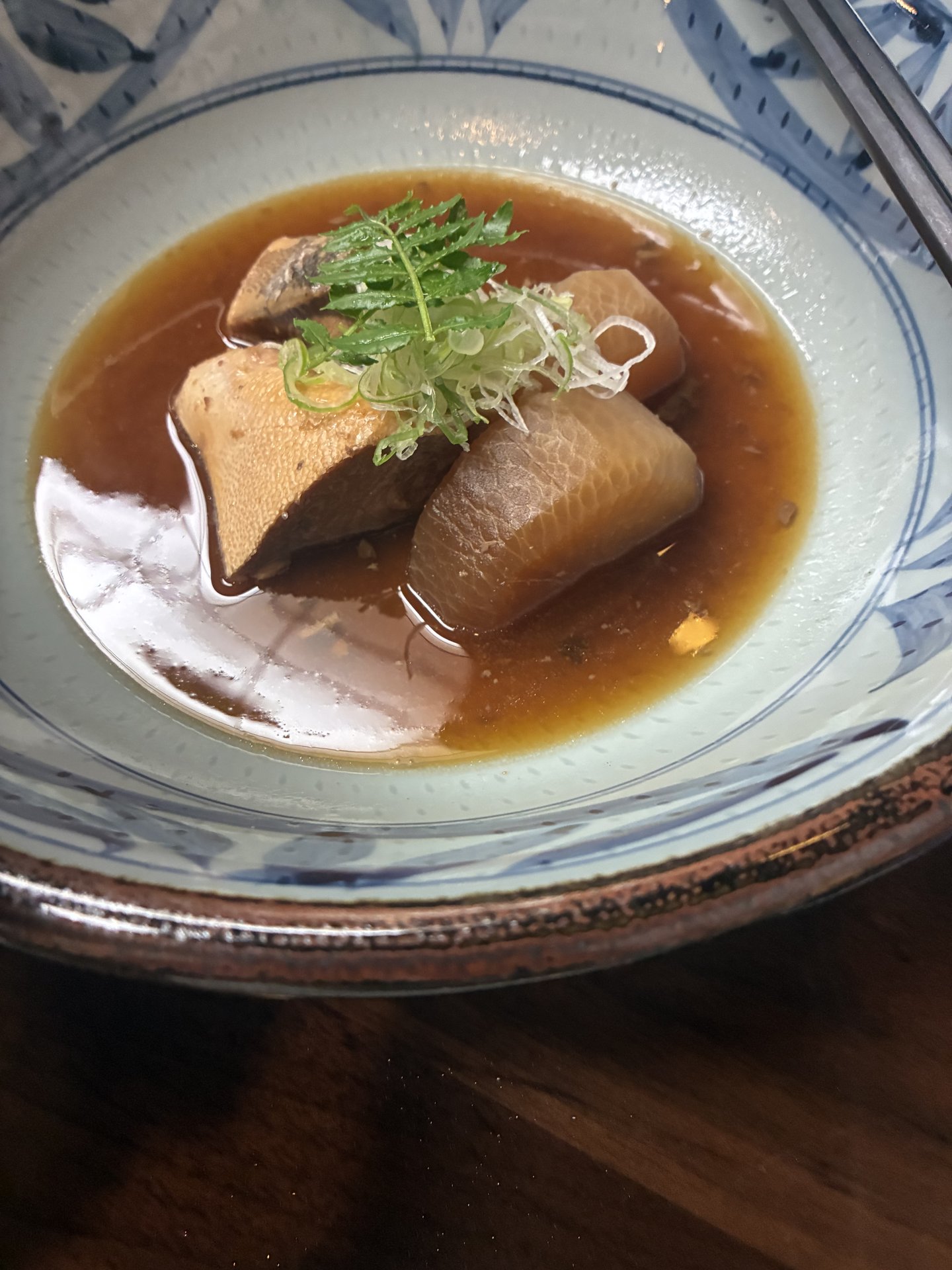 Buri daikon (simmered yellowtail with daikon radish) on Night 2 at Yarimikan in a blue-and-white porcelain bowl
